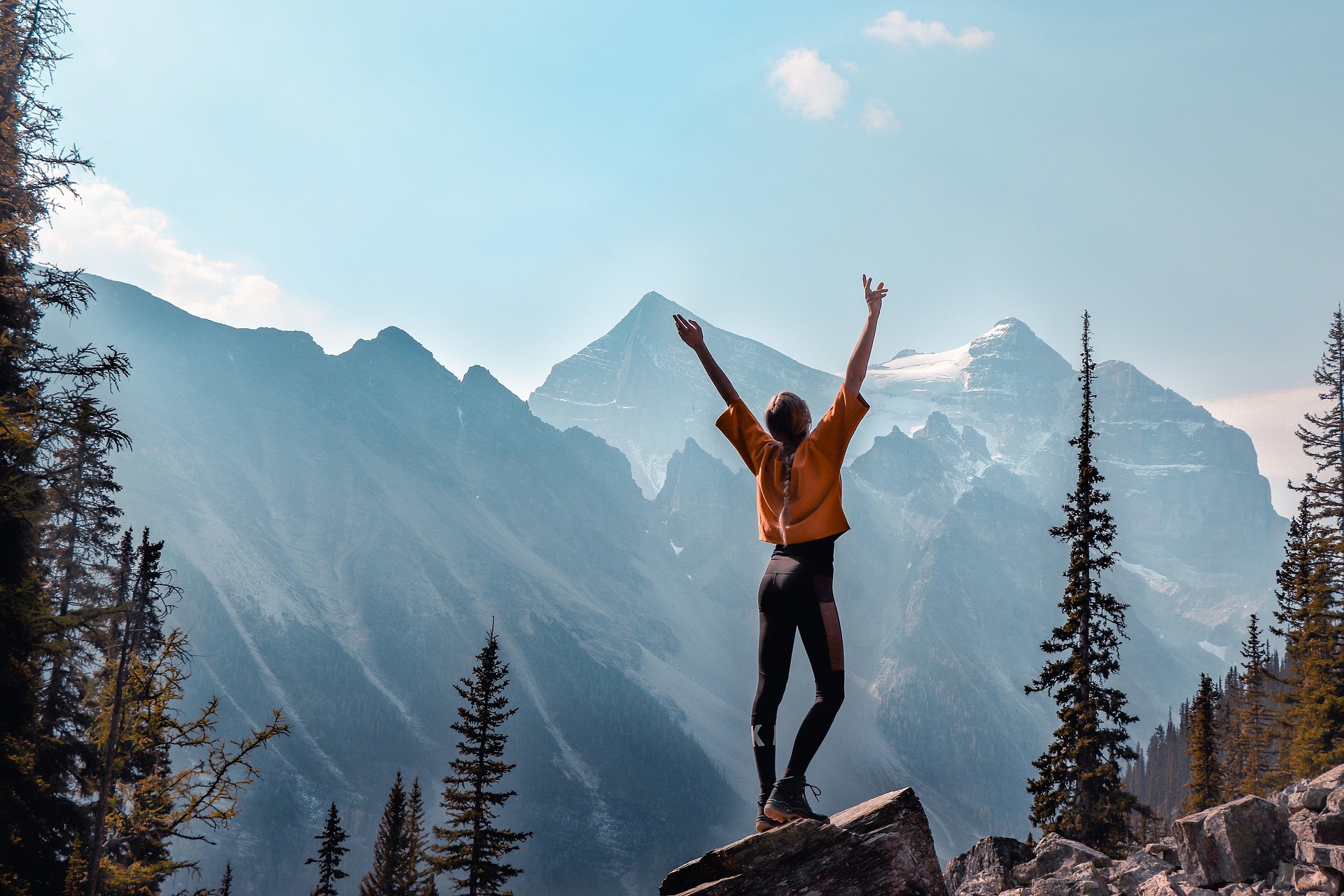 Person with arms raised on mountain summit